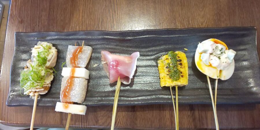 Osaka: Shinsekai Food Tour with 13-15 Dishes at 5 Eateries - Stop 2: an izakaya lineup, kitsune udon, yakitori, wings, and nagaimo